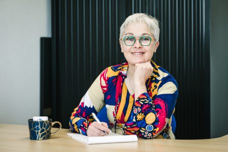 Myrtille assise à son bureau avec un sourire bienveillant